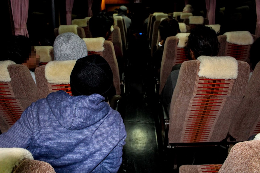 People sit in a dark bus