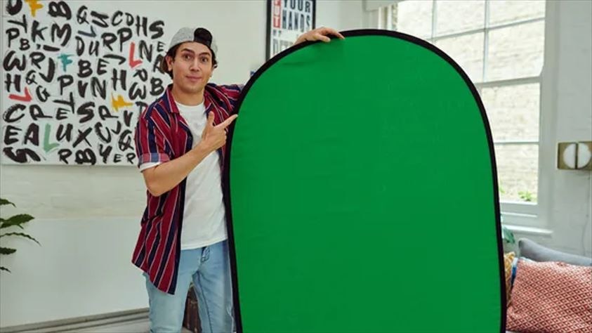 Man points to a green screen