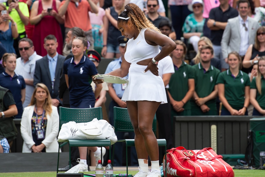 Serena Williams reads her plate-style trophy one the court after the 2019 Wimbledon final against Simona Halep.