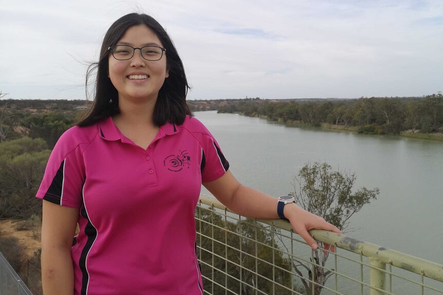 Jenny Han standing at a lookout with the River Murray in the background on a cloudy day.
