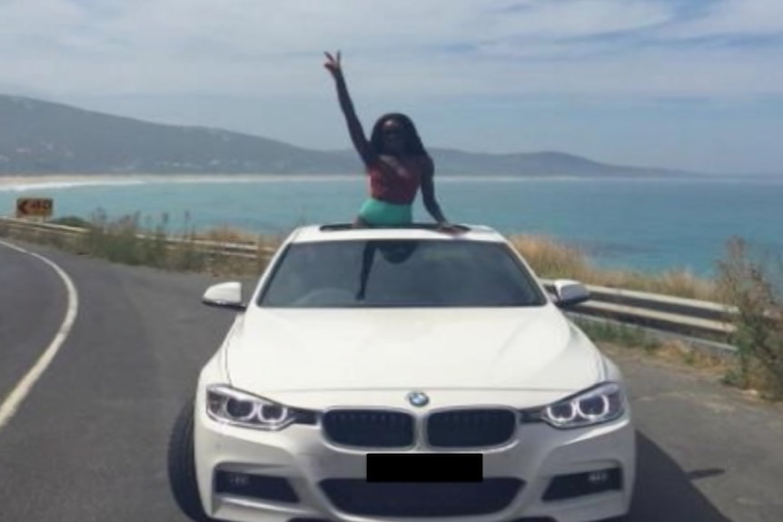 General Hoth Mai's daughter in a BMW convertible driving along the coast of Australia.