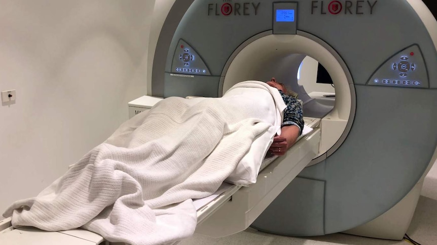 David Astle lies down in a mock fMRI machine at the Florey Institute in Melbourne.