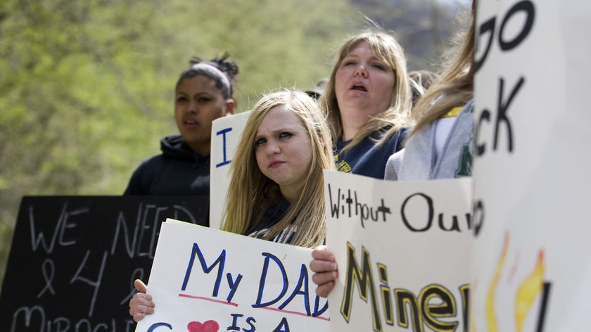 People holding signs show support for the lost coal miners in Montcoal