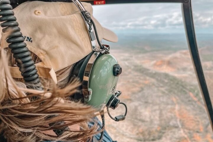 A woman sits inside a helicopter