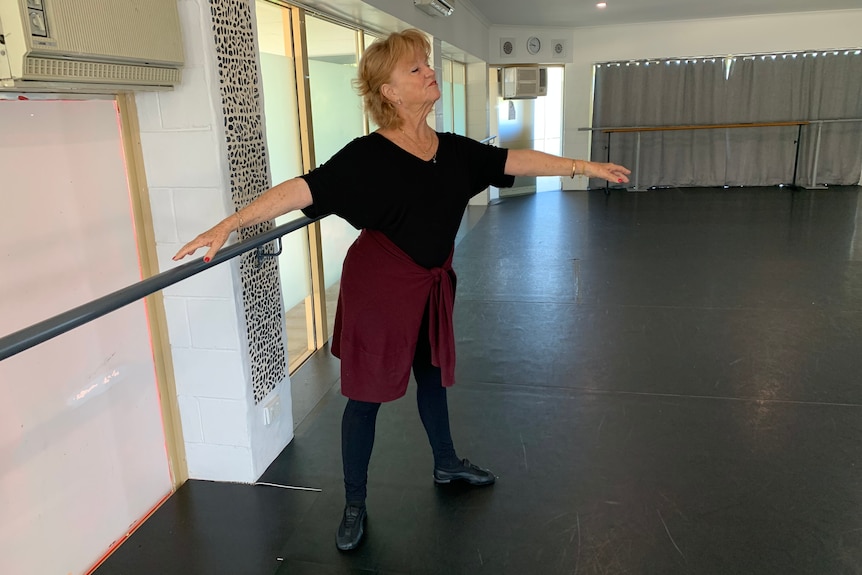 Seniors ballet instructor Lenore Robbins in a dance pose while teaching students at her Gold Coast studio