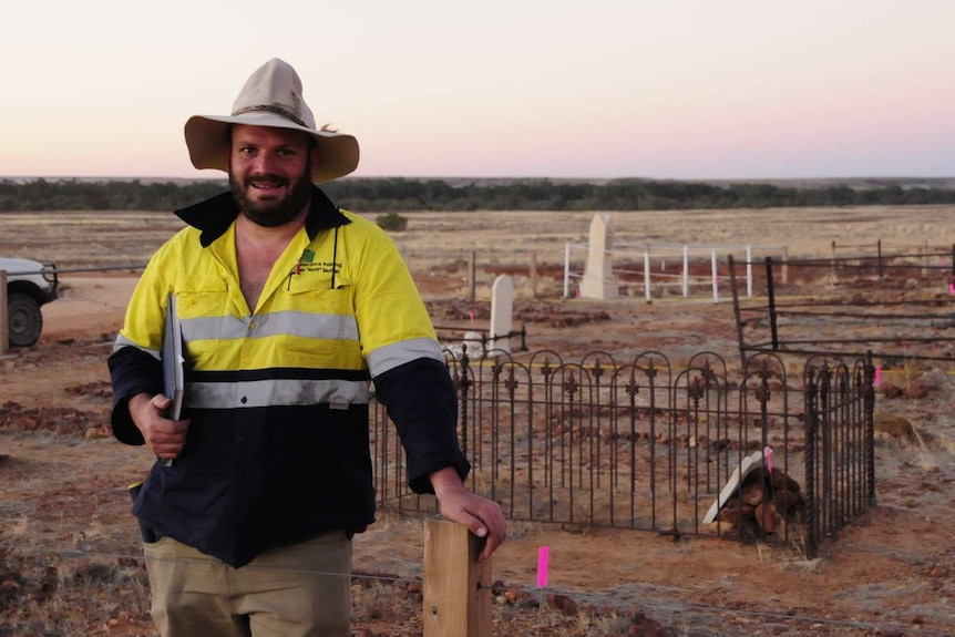 Dr Ian Moffat standing in front of a grave site