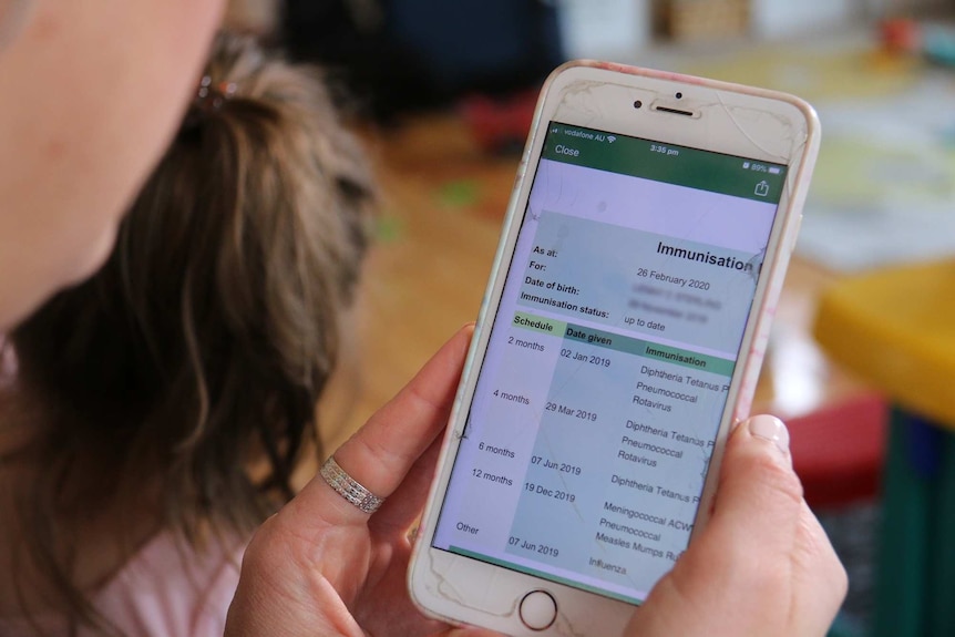 A close up shot of a green and white mobile phone screen showing the Centrelink immunisation information for a family.
