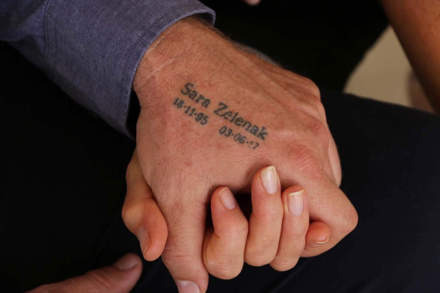 The tattooed hand of Mark Wallace with the text 'Sara Selenak - 18.11.95 - 03.06.17'.