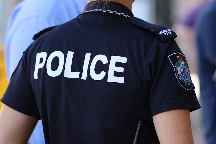 Short sleeved dark navy police t-shirt, viewed from back of officer in uniform