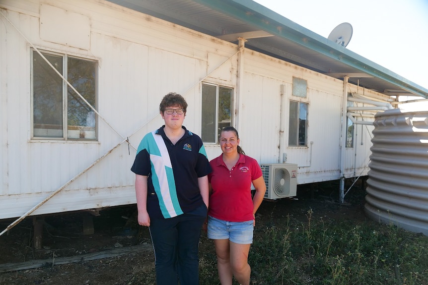 Campbell West and Bianca Sanders stand in front of the schoolroom