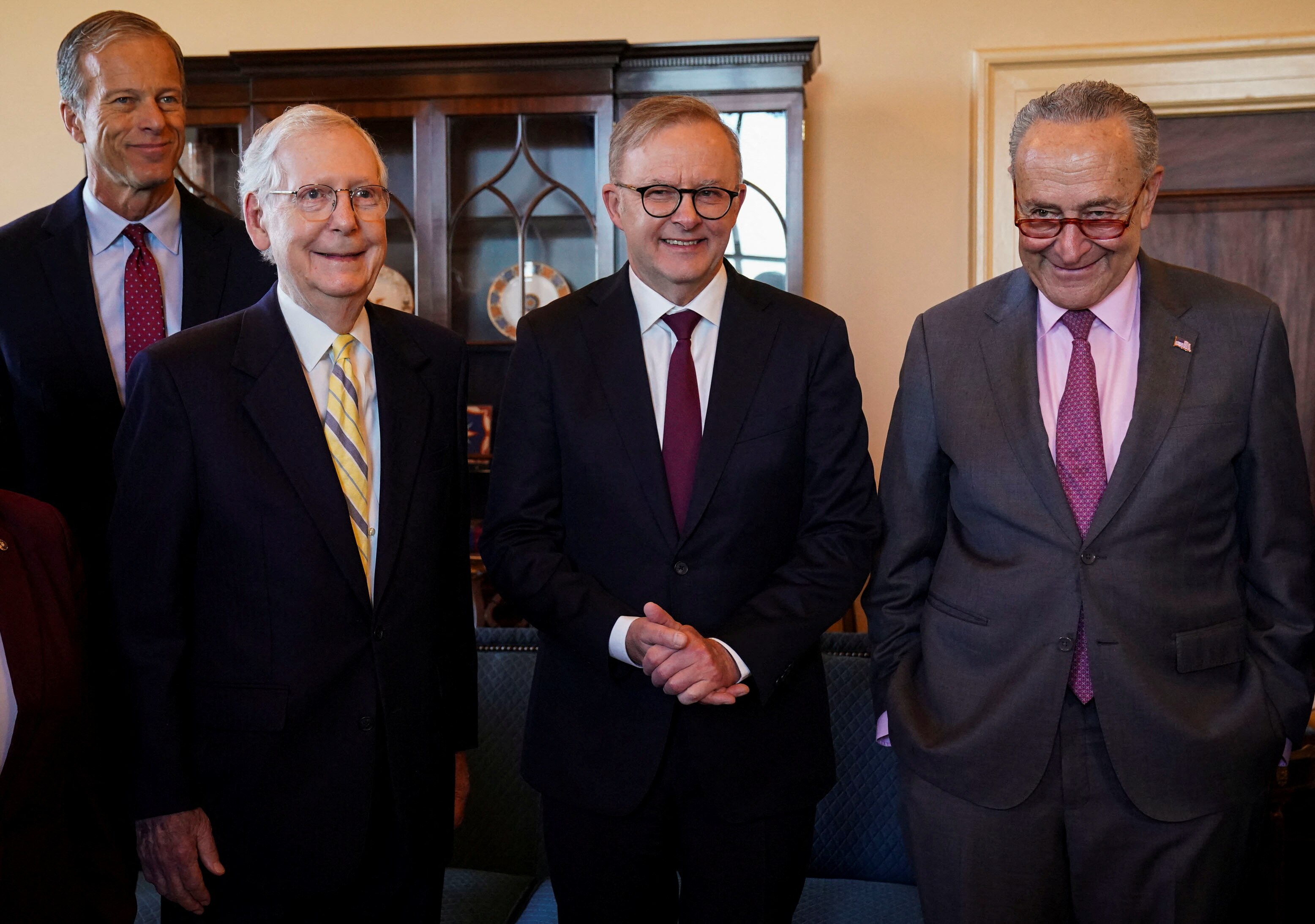 The three men stand side by side and smile.