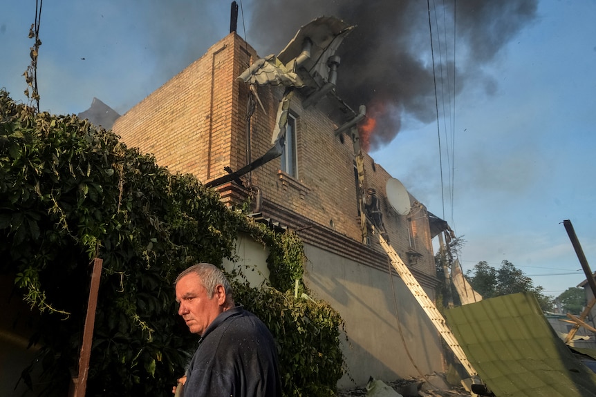 A local resident is seen at a site of a private house heavily damaged in a Russian shelling