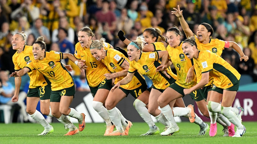 The women Matildas soccer team on the field celebrating a goal