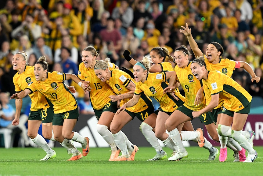 The women Matildas soccer team on the field celebrating a goal