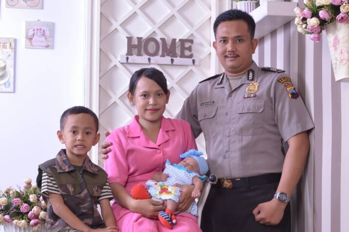 An Indonesian family pose for a photo in their house.