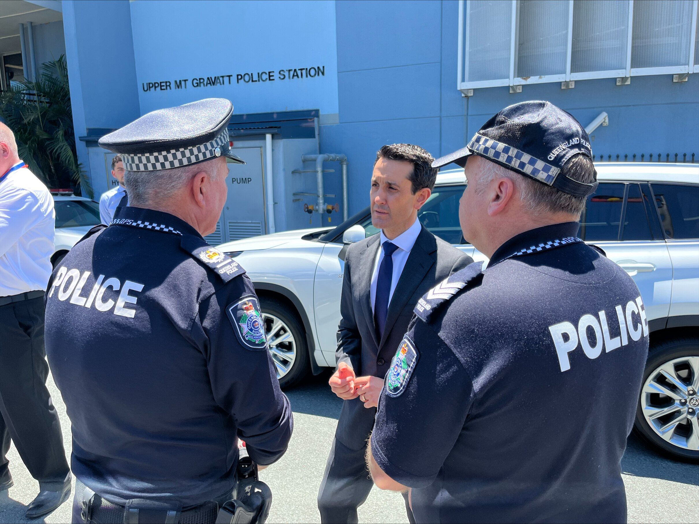 A man in a suit with a few police officers. 