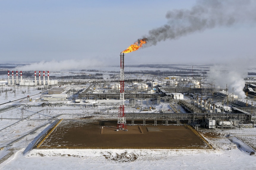 A flame burns from a tower at an oil field in Siberia