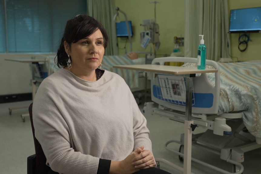 Dr Ward sits in a hospital ward looking stern.