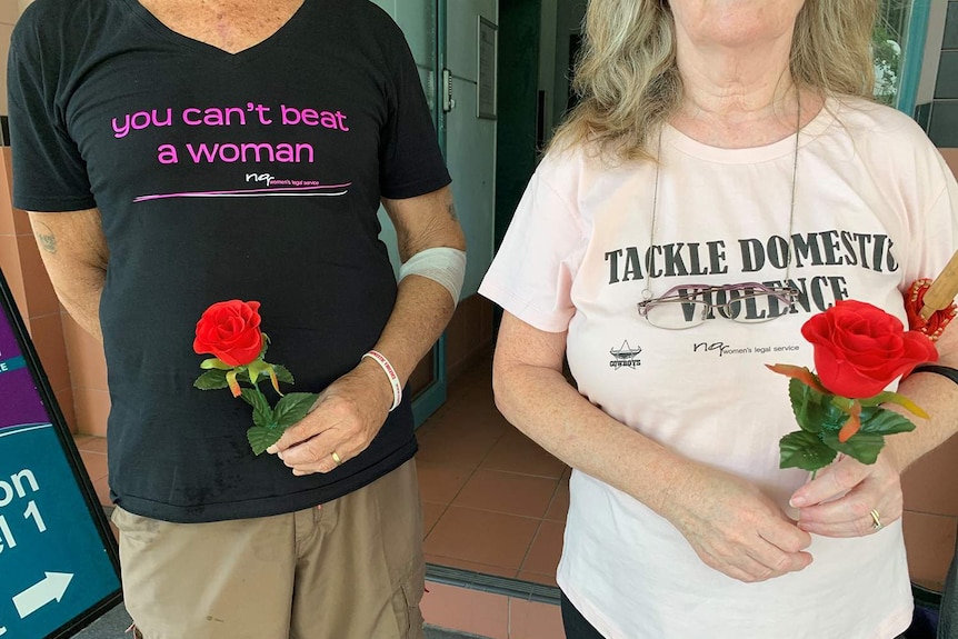 Two people wearing anti-domestic violence t-shirts at a silent Red Rose anti-domestic violence rally in Townsville