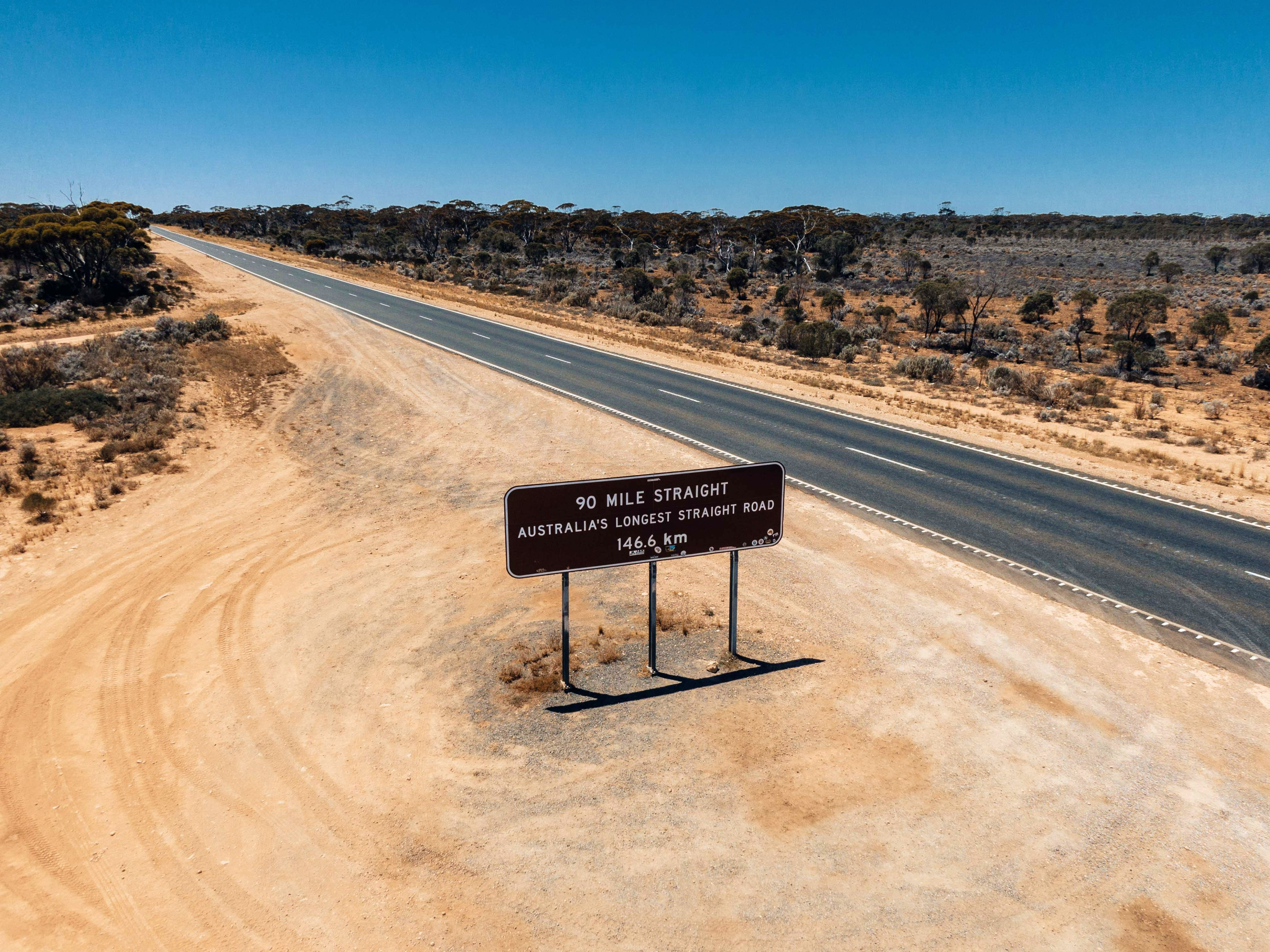 A sign alongside a straight flat country highway