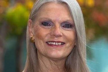 A woman smiles for a professional portrait.