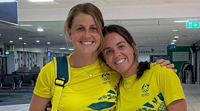 Savannah and Madison both wearing their casual Australian team uniform, yellow top and green shorts, smiling.