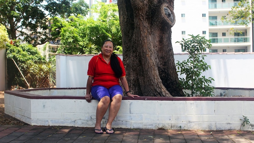 Camille Fong Lim sits under a tree in Darwin