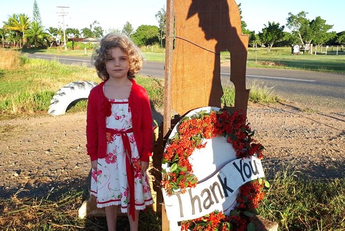 Little girl stands beside thank you sign on a rural property at Mareeba.