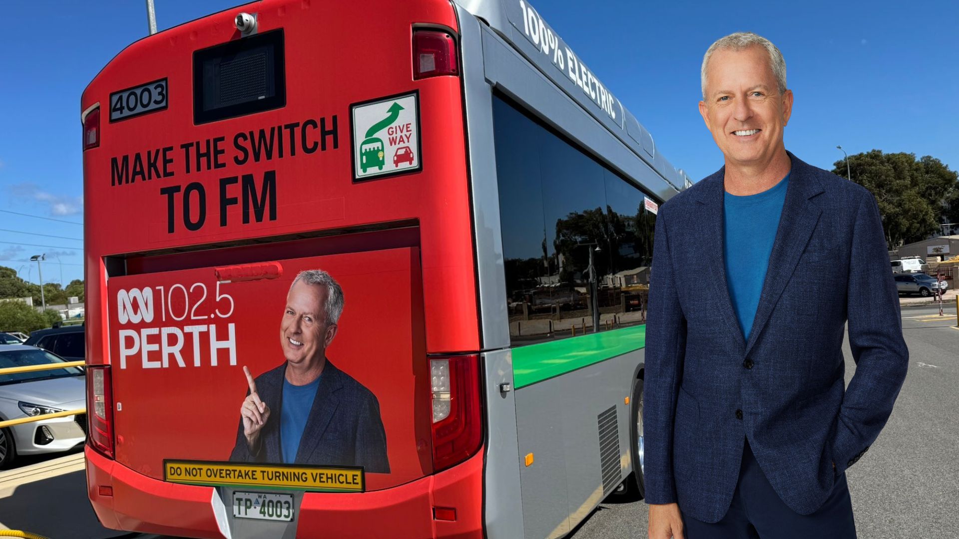 A bus with a man standing next to it