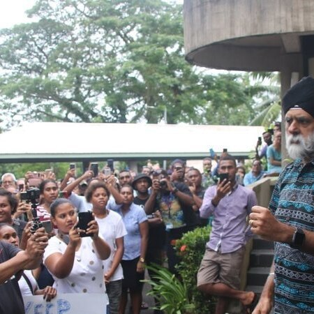 Professor Pal Ahluwalia with a sea of students taking photos of him.