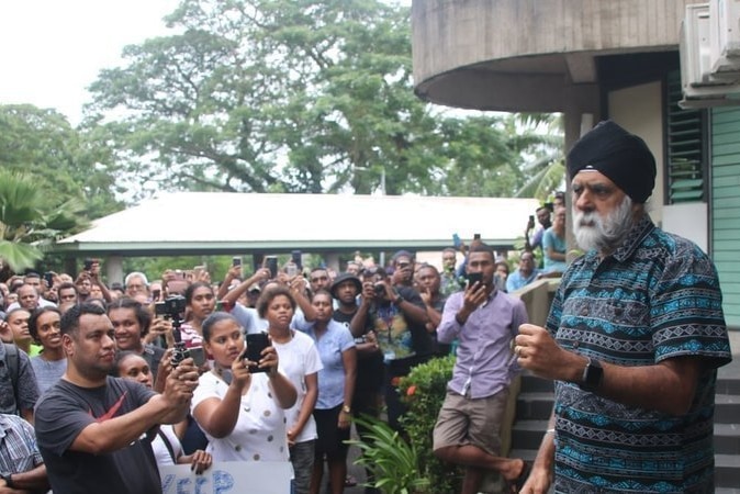 Professor Pal Ahluwalia with a sea of students taking photos of him.