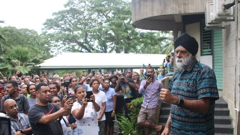 Professor Pal Ahluwalia with a sea of students taking photos of him.