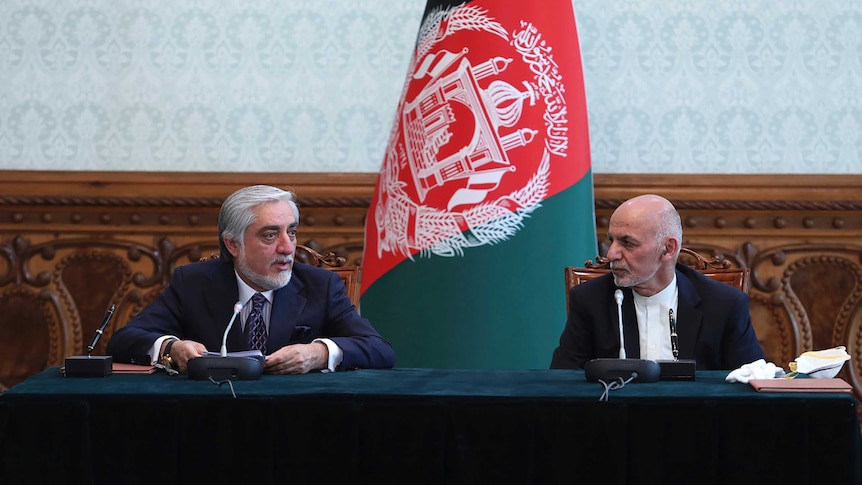 Afghan President Ashraf Ghani, right, and political rival Abdullah Abdullah speak.