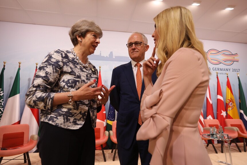 Malcolm Turnbull stands between British Prime Minister Theresa May and Donald Trump's daughter Ivanka, who are talking