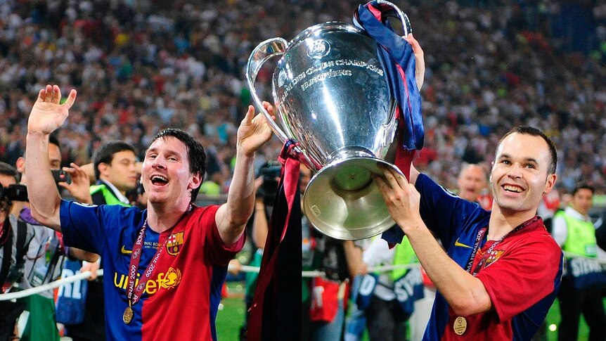 Andres Iniesta lifts the Champions League trophy with Lionel Messi