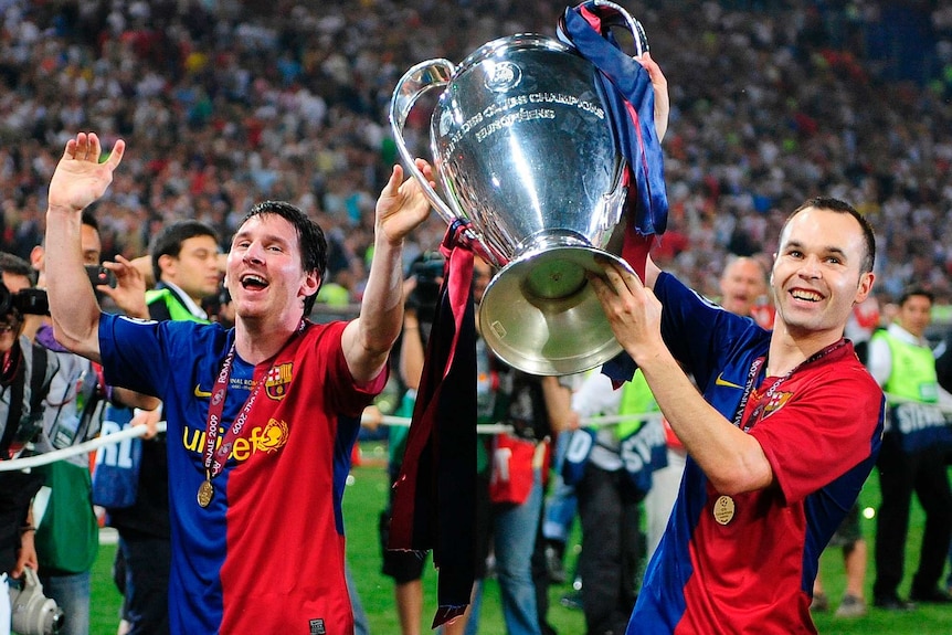 Andres Iniesta lifts the Champions League trophy with Lionel Messi