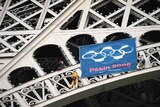 Protesters unfurl a flag - with handcuffs instead of Olympic rings - on the Eiffel Tower in Paris
