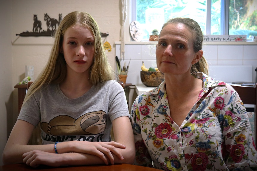 Summer Van Andel and Gabrielle Taylor sit at a table inside their home.