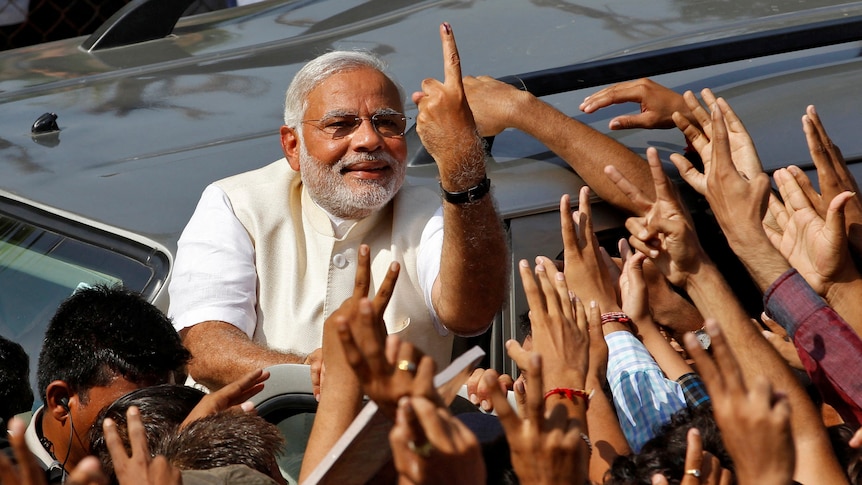 A man points his finger as people reach up 