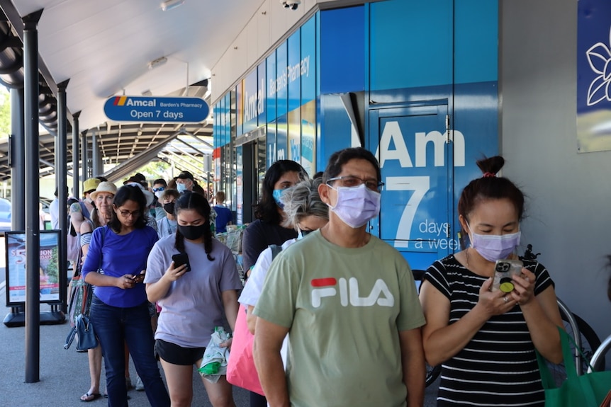 A long queue forms outside a chemist in Darwin.