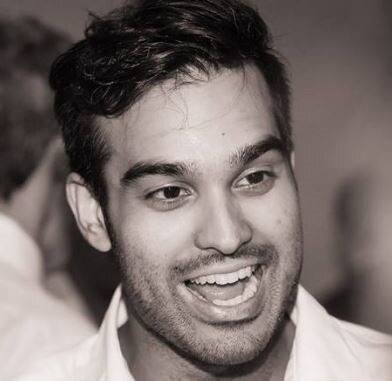 A black and white close-up image of Lucas Marie smiling.