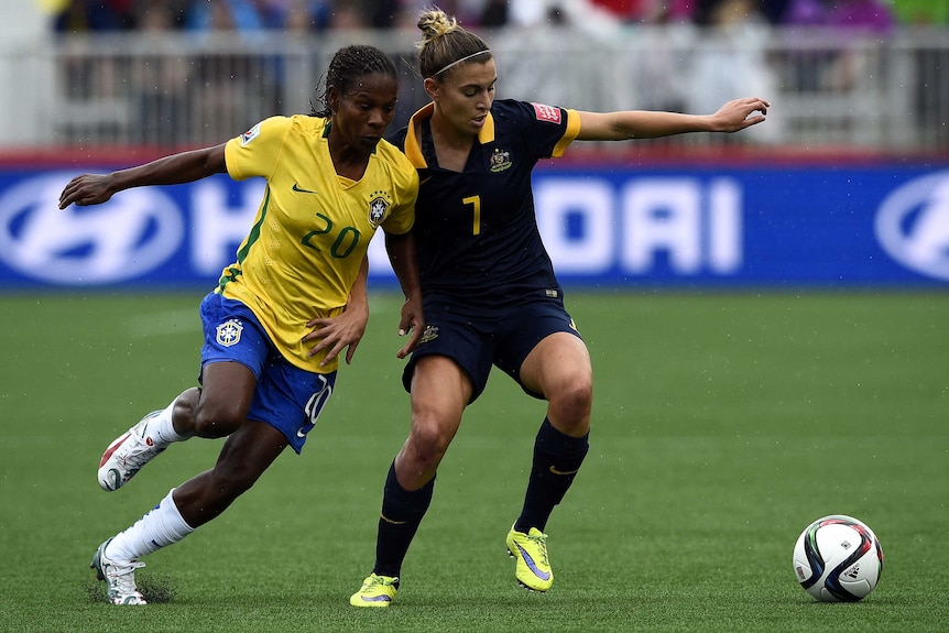 Steph Catley holds off Brazil's Formiga