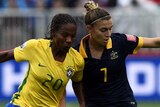 Steph Catley holds off Brazil's Formiga