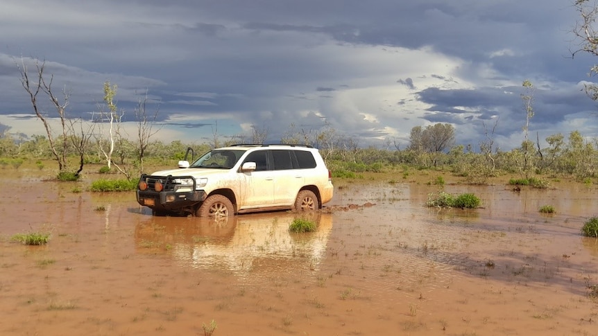 A white 4WD in floodwaters.