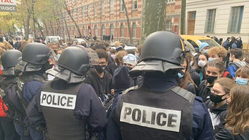 Riot police form a line in front of student protesters in Paris.