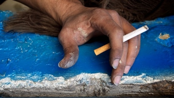 Photo of Indigenous hand holding a cigarette.