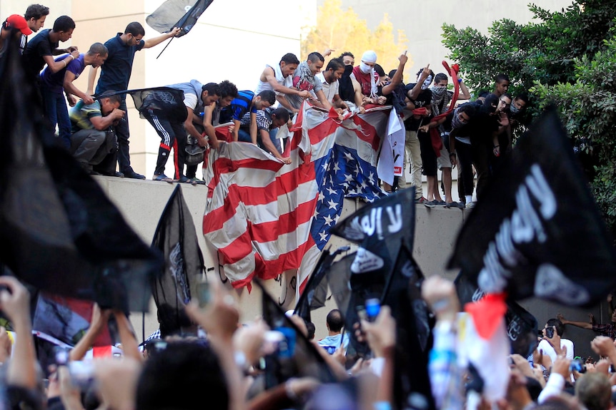 Protesters destroy an American flag pulled down from the US embassy in Cairo.