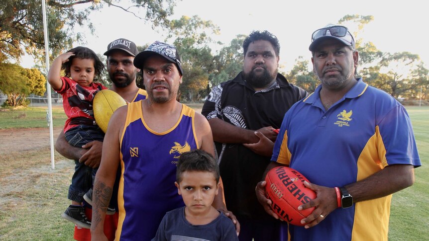 Sam mitchell with group of Aboriginal football players and their kids.