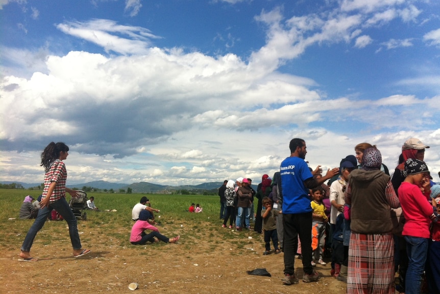 Asylum seekers at the Idomeni camp queue for food.