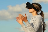 A woman wearing VR goggles outside.